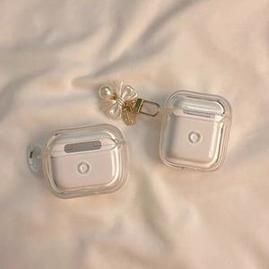 Detalle de funda transparente para AirPods con elegante colgante de lazo de perlas