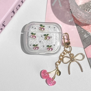 Detail of glitter cherry earphone case for AirPods with gold bow and cherry charm chain