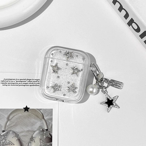 Macro detail of transparent AirPods case with silver star studs and pearl star pendant