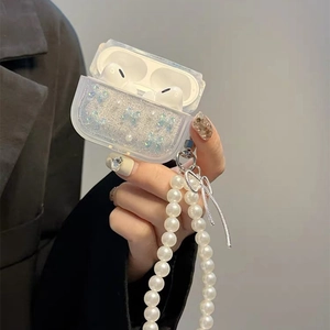 Detail view of transparent AirPods Pro case with blue butterfly, glitter, and pearl chain