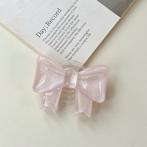 Dettaglio dell'impugnatura per telefono a fiocco glitter rosa con base trasparente