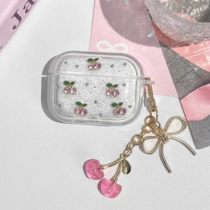 Detail of glitter AirPods Pro case with pink crystal cherries and gold bow keychain