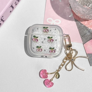 Detail of clear Airpods case with pink glitter cherry charm and metal lanyard