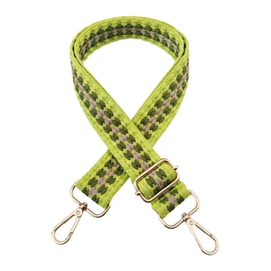 Close-up of green checkerboard woven bag strap with gold metal swiveling hooks