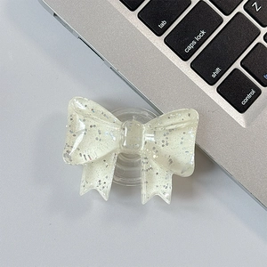 Close-up of a semi-transparent glittery bow-shaped expandable phone socket and stand