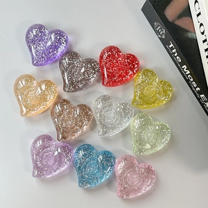 Colorful glitter heart-shaped phone stands in transparent resin shown on white background