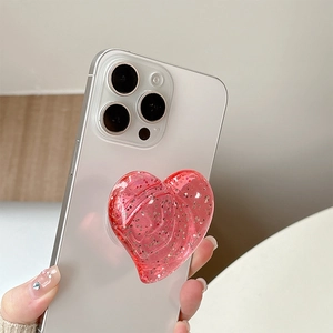 Macro detail of red glitter heart phone grip with sparkling sequins on smartphone
