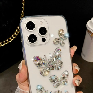 Detailed macro view of sparkling rhinestone butterfly embellishments on a clear phone case