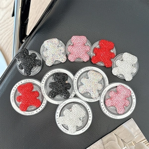 Detailed view of colorful rhinestone bear phone grips on a premium leather texture