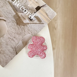 Detail of pink rhinestone bear phone grip showing sparkling crystals and collapsible stand