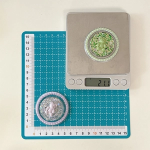 Vue détaillée d'un support de téléphone ours pailleté de 5cm avec perles sur une balance
