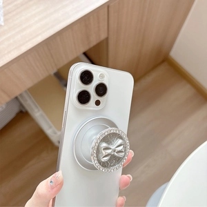 Magnetic silver bow phone grip with diamond border on white smartphone