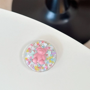 Détail d'un support MagSafe rond avec un ours rose mignon et des paillettes en cœur
