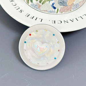 Detail of seashell texture phone socket with a colorful heart and sparkling rhinestones