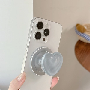 Macro view of light blue heart-shaped expanding phone grip on a white smartphone back