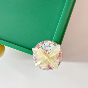 Close-up of heart sequins and ribbon bow on a cute butterfly phone grip holder