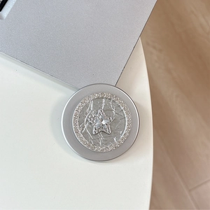 Macro view of a silver magnetic phone grip featuring a rhinestone-studded star design