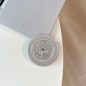 Macro shot of silver magnetic phone grip featuring a sparkling rhinestone cherry design