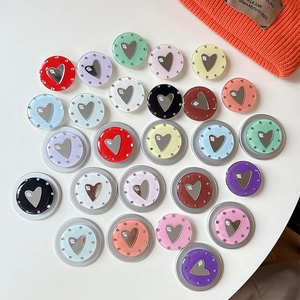 Close-up of heart-shaped mirror phone grips in various colors with a soft lifestyle aesthetic