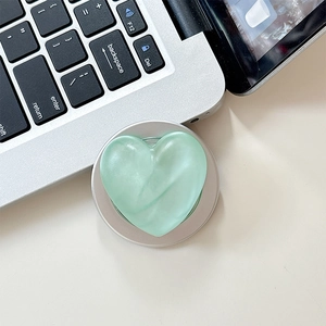 Detailed view of mint green matte heart phone socket with silver metal rim on desk