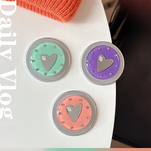 Detailed macro view of mint green and coral heart-shaped metal phone grip accessories