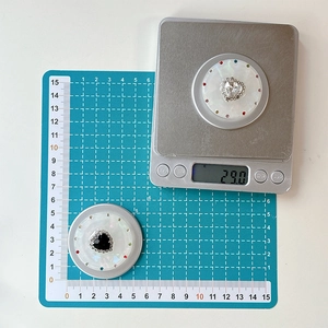 Macro shot of rhinestone heart phone socket showing 29g weight on digital scale