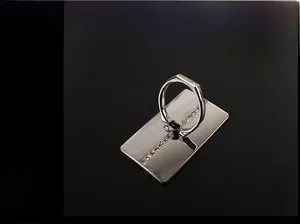 Detail eines silbernen Handy-Ringhalters aus Metall mit Strasssteinen auf quadratischer Basis
