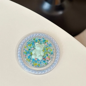 Détail du support téléphone ours à paillettes colorées et bordure de perles sur fond blanc