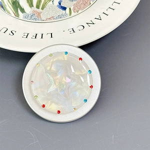 Macro shot of phone socket with pearl shell texture, star design and colorful rhinestones