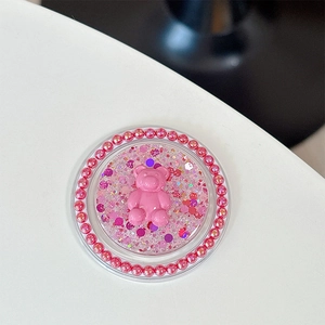Détail d'un support de téléphone pailleté rose avec ours 3D et billes métalliques