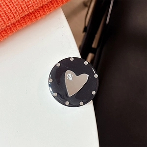 Close-up of a black heart mirror phone grip with mine text and sparkling rhinestones