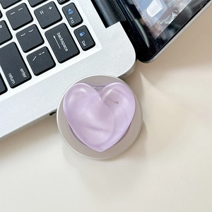 Detail of light purple heart-shaped Magsafe phone grip and retractable socket on a laptop