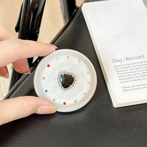 Macro shot of magnetic phone grip with black heart gem and multicolored rhinestones