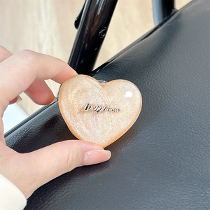 Close-up of glittery heart-shaped magnetic phone grip with Luckyhorse metallic logo detail