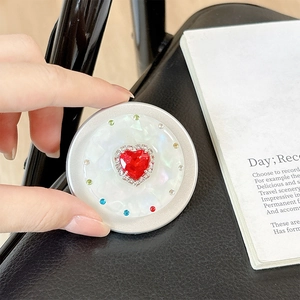 Detailed close-up of a magnetic heart rhinestone phone socket with red crystal on white base