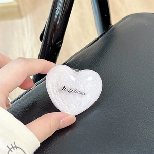 Macro shot of pink glitter heart Magsafe phone grip with metal Luckyhorse emblem