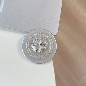 Detail of silver clover phone grip with sparkling rhinestones and textured metal finish