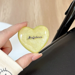 Macro shot of heart-shaped Magsafe grip with yellow glitter and Luckyhorse metal logo