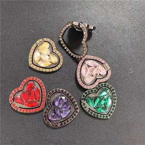Macro view of heart-shaped rhinestone phone ring holders in five vibrant metallic colors