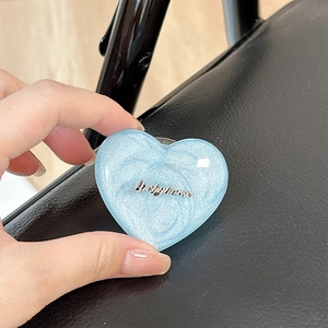 Detail of blue heart MagSafe phone grip with glitter finish and Luckyhorse logo