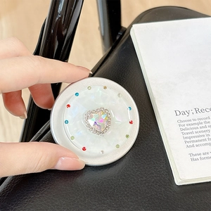 Macro shot of heart-shaped crystal phone grip with multi-colored rhinestone border