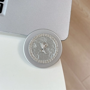 Macro shot of silver magnetic phone holder with embossed rose and sparkling rhinestones