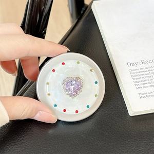 Macro detail of magnetic heart-shaped rhinestone phone socket with glitter mica finish