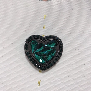 Detail of heart-shaped phone ring holder with dark green crystals and black nickel base