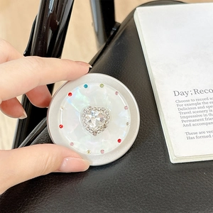Detail of magnetic telescopic phone socket with heart rhinestone and pearlescent finish
