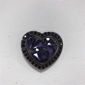 Close-up of heart-shaped phone ring holder with purple rhinestones and dark nickel base
