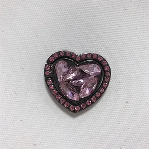 Macro shot of heart-shaped phone ring holder with pink rhinestones on black metal base