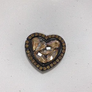 Macro detail of heart-shaped metal phone ring holder with rhinestones and champagne gems