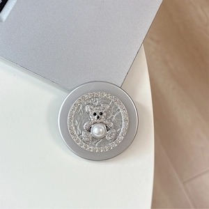 Close-up of silver magnetic MagSafe phone grip with rhinestone bear and pearl detail