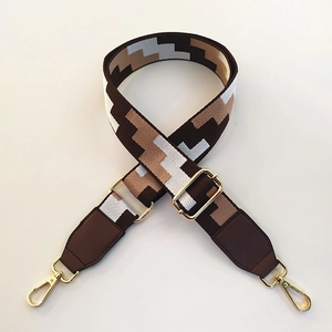 Close-up of adjustable woven shoulder strap with brown and beige geometric pattern